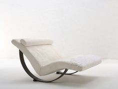 a white reclining chair sitting on top of a metal base with a cushion over it