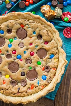 a cookie pie with m & m cookies on top and candy in the middle, ready to be eaten