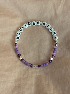 A hand-crafted glass bead friendship bracelet highlighting Olivia Rodrigo's song "Bad Idea, Right?"! A simple and cute way to show off your favorite song or a great concert accessory!  This bracelet is made with Czech glass beads, plastic letter beads, plastic spacer beads, and is on an elastic thread measured at about 10 inches in length for a relaxed/loose fit. If you would like the bracelet you order to be smaller or larger, please leave the requested size in inches in the personalization box!  All bracelets are made to order and are typically shipped out within 1-3 business days unless otherwise stated. Beaded Bracelet With Letters, Olivia Rodrigo Friendship Bracelet Ideas, Letter Bracelet Ideas, Olivia Rodrigo Friendship Bracelet, Olivia Rodrigo Bracelets, Olivia Rodrigo Bracelet Ideas, Letter Bracelet Beads Ideas, Olivia Rodrigo Bracelet, Concert Bracelets