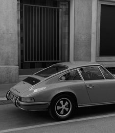 an old porsche parked on the side of the road