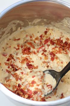 a spoon in a bowl filled with batter and toppings on the side, ready to be mixed together