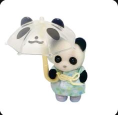 a small panda bear holding an umbrella