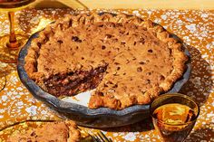 a pie sitting on top of a table next to two glasses