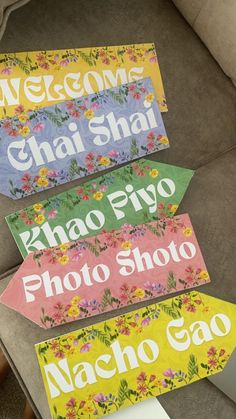 four wooden signs that say welcome, chai shai, khao piyo, photo shop, nacho go