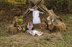 a group of children dressed up as nativity scene with baby jesus and mary in hay bales