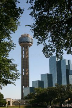 a tall tower with a glass dome on top in the middle of a city park