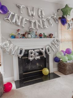 a birthday party with balloons and streamers in front of a fireplace decorated for someone's 90th birthday