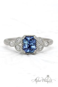 an engagement ring with a blue stone surrounded by diamonds