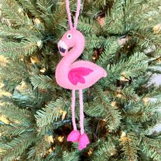 a pink flamingo ornament hanging from a christmas tree