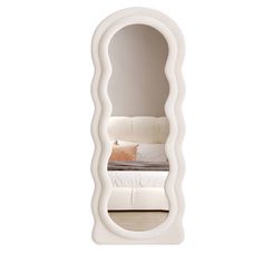 an oval shaped mirror with a bed in it