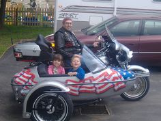 a man and two children on a motorcycle with an american flag painted on the side