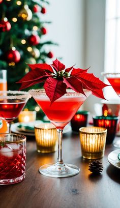 a table topped with glasses filled with different types of drinks next to a christmas tree