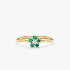 a gold ring with green and white stones