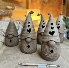 three clay gnomes with hearts painted on them