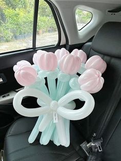 a bunch of balloons sitting in the back seat of a car with flowers on it