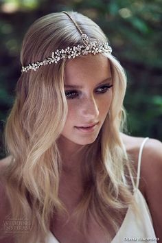 a woman with long blonde hair wearing a headband made of pearls and crystals on her head