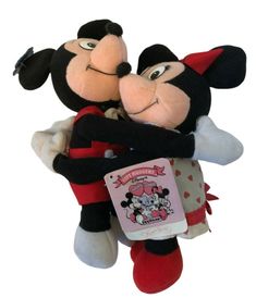 two stuffed mickey and minnie mouses hugging each other