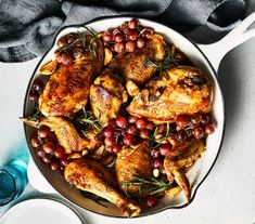 a pan filled with chicken and berries on top of a counter next to water bottles