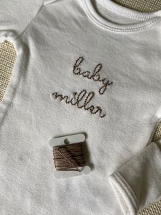 a white shirt with the words baby million written on it next to a spool of thread