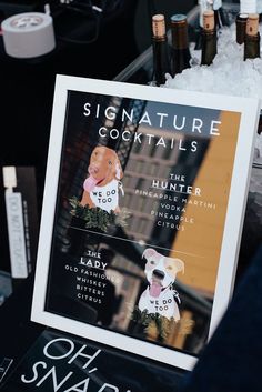 there is a sign that says signature cocktails on the table next to bottles of booze