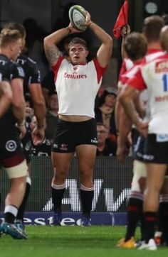 a rugby player is holding the ball above his head