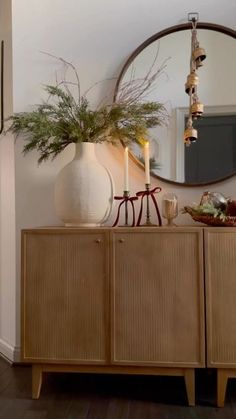 a wooden cabinet sitting in front of a mirror on top of a hard wood floor