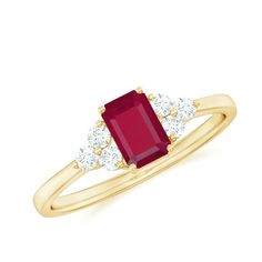 a yellow gold ring with an oval ruby stone and three diamonds