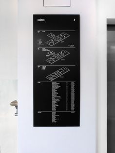 a black and white poster hanging on the side of a wall