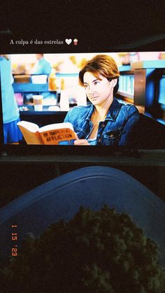 a bowl of food sitting on top of a table in front of a tv screen