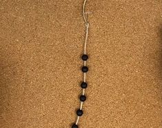 a black and white beaded necklace is laying on the ground