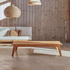 a couch and table in a room with wood paneling on the wall behind it