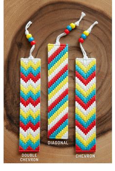 two colorful beaded bookmarks sitting on top of a piece of wood next to each other