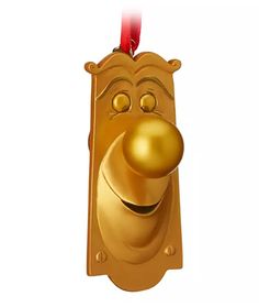 a golden door knocket with a red ribbon hanging from it's face and nose