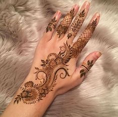 a woman's hand with henna tattoos on it