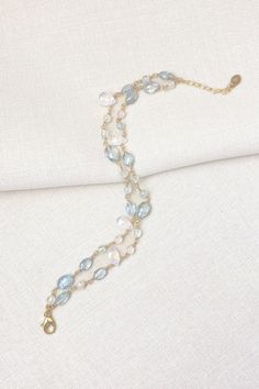 This bracelet showcases delicate moss aquamarine gemstones paired with radiant rainbow moonstones, creating a lovely, feminine style. The artisan meticulously hand-wire-wraps each gemstone bead, creating a beautiful, double-layered chain. The lobster claw clasp and extender chain allow for an adjustable fit. Bracelet length: 7 inches plus 1-inch extender chain Materials: aquamarine, rainbow moonstone, gold fll Aquamarine Beaded Bracelet Jewelry, Elegant Double Strand Natural Stones Bracelets, Elegant Aquamarine Beaded Bracelets With Natural Stones, Elegant Aquamarine Bracelets With Natural Stones, Elegant Wire Wrapped Crystal Bracelet, Elegant Hand Wrapped Moonstone Jewelry, Elegant Hand-wrapped Moonstone Jewelry, Elegant Double Strand Jewelry With Extender, Moss Aquamarine