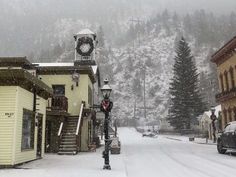 a clock tower on top of a building in the middle of a snow covered street