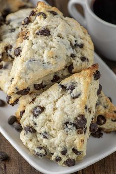 chocolate chip scones on a plate next to a cup of coffee