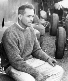 a man sitting on the ground next to some tires