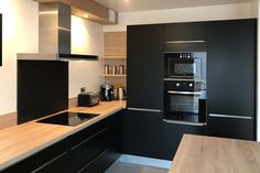 a modern kitchen with black cabinets and stainless steel appliances