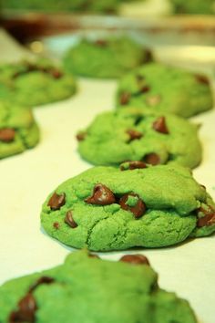 green cookies with chocolate chips are lined up on a table