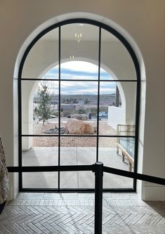 an arched glass door leading to a patio with a view of the desert and mountains