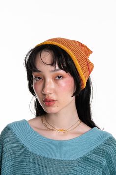 a woman wearing a blue sweater and orange hat