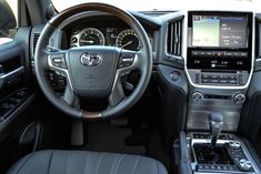 the interior of a car with steering wheel, dashboard and touchscreens on display