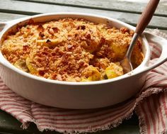 a casserole dish with potatoes and crumbs in it on a red and white towel