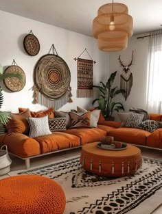 a living room filled with lots of orange couches and pillows on top of a rug