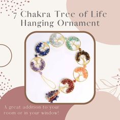 the 7 chakra tree of life hanging ornament is shown in front of a pink and white background