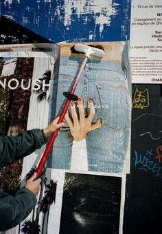 a man is painting the side of a wall with various pictures and words on it