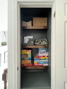 an open closet with books and baskets on the shelves