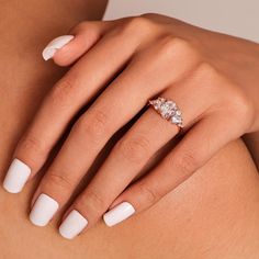 a woman's white manicured nails and ring