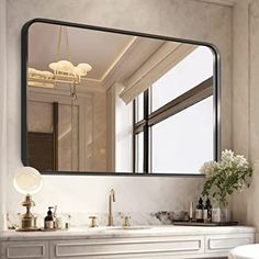 a bathroom with a large mirror above the sink and a white toilet next to it